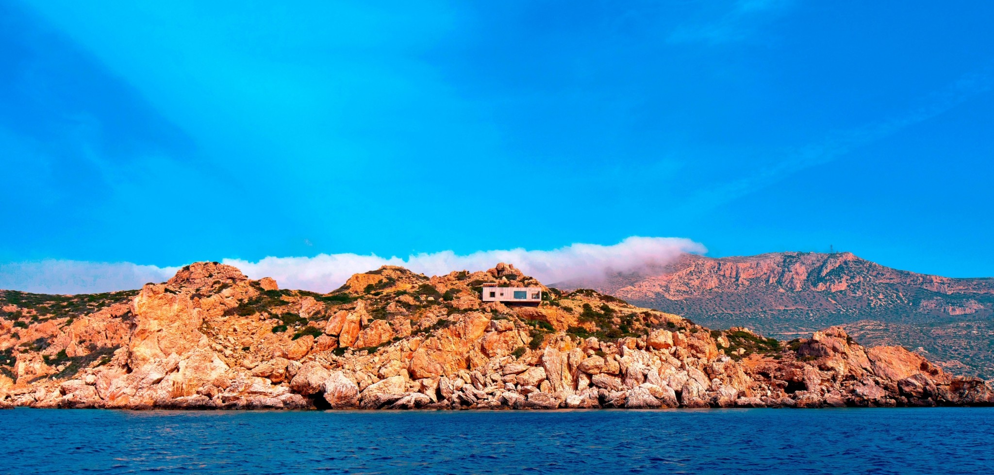 Η ιστορία πίσω από το βραβευμένο σπίτι που “κρεμάστηκε” φυσικά σε έναν βράχο της Καρπάθου